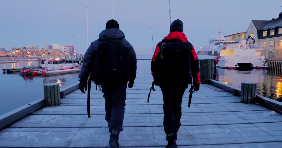 Two men walk on a icy pier
