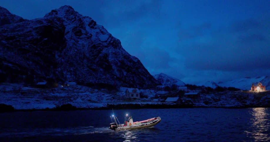 A boat travels on antarctic waters at night