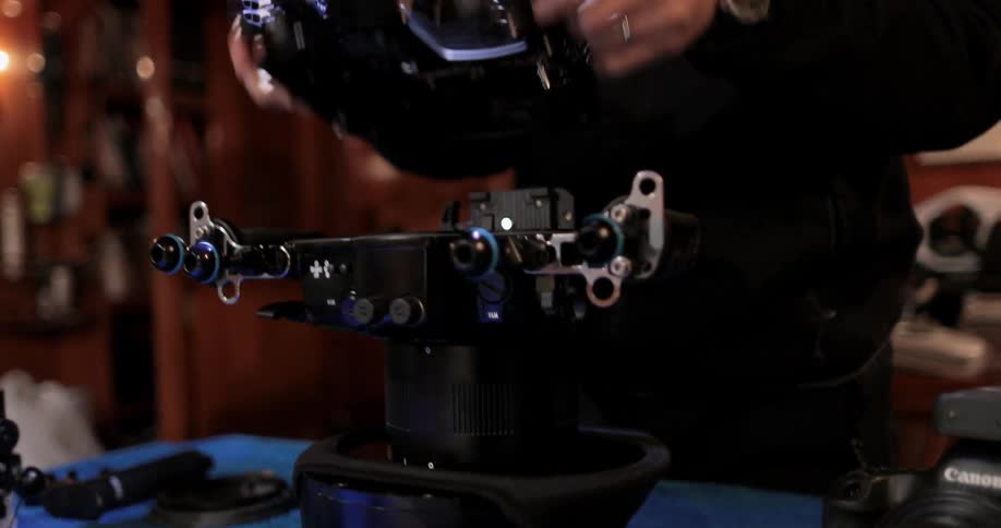 A man works with equipment while wearing a headlamp