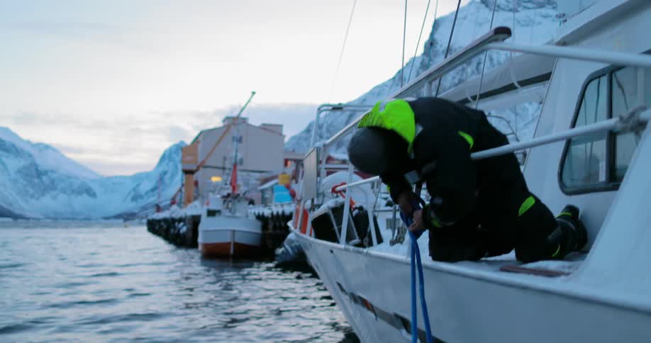 Man untying a line attached to the side of his boat