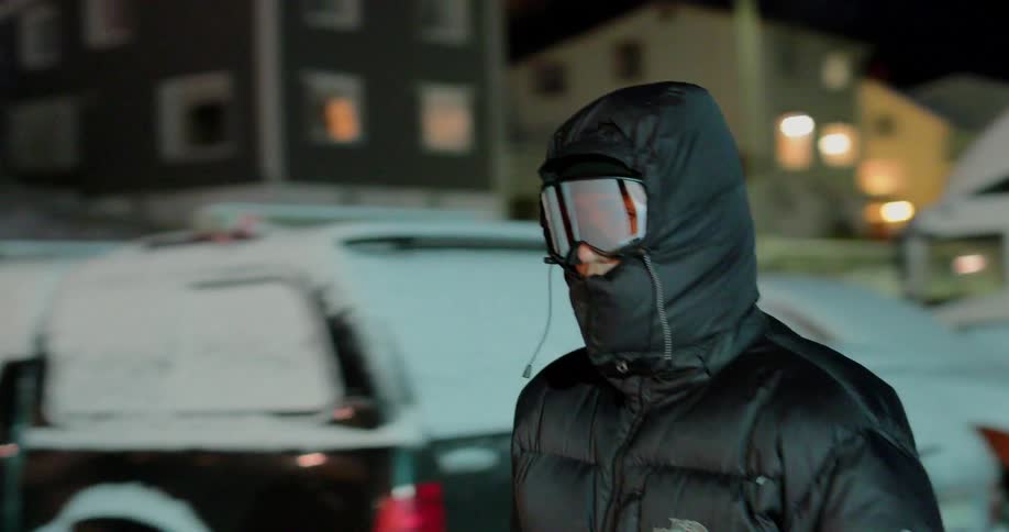 Person heavily covered walks through a town area in the snow