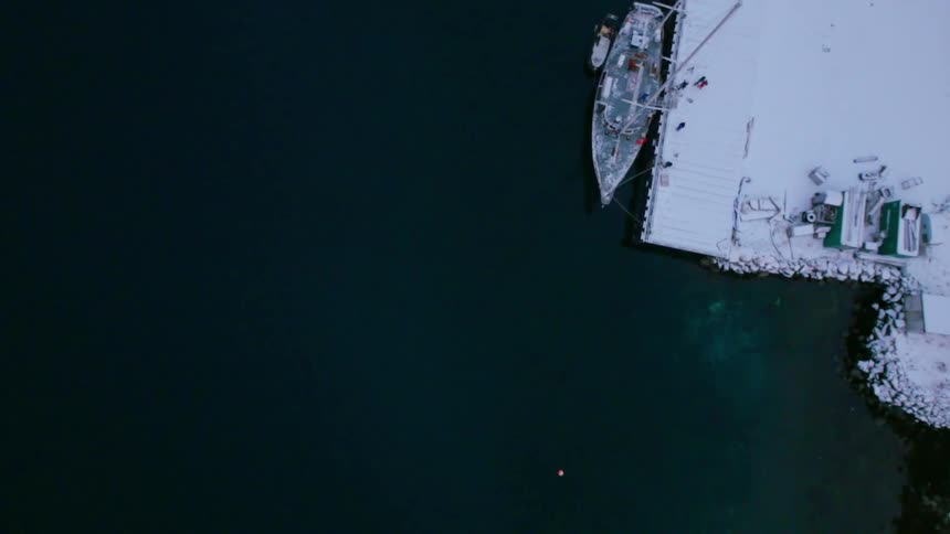 A boat is docked at a snow covered dock