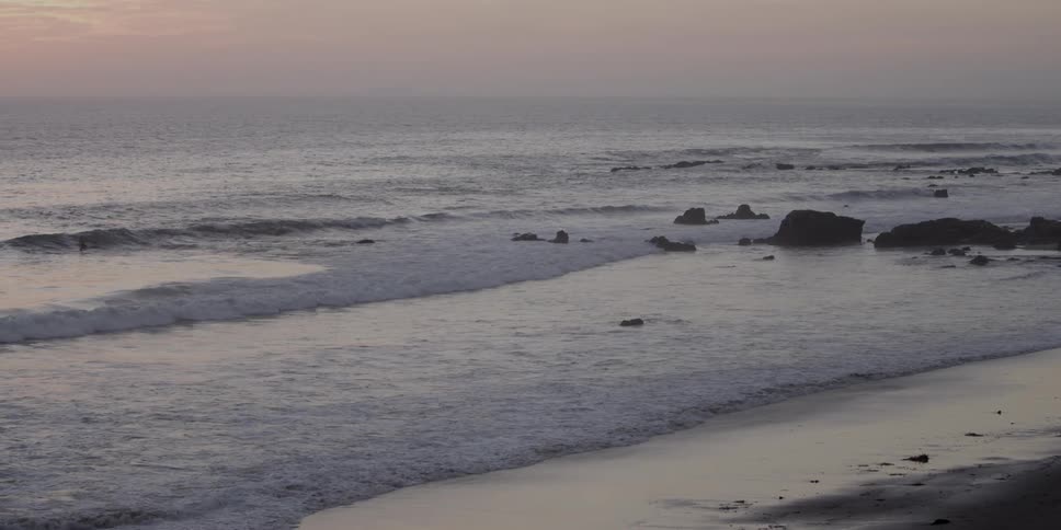Waves hit the shore on a cloudy day
