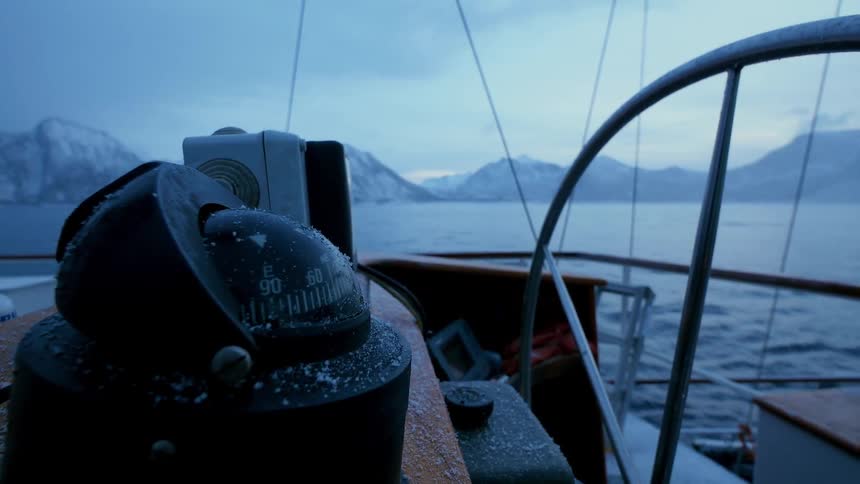 People navigating a boat in a very cold and cloudy area