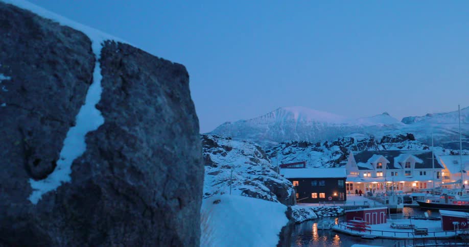 A house sits in snowy mountains at dawn