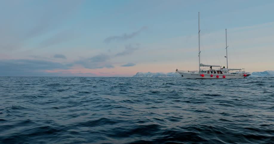 A ship sails on the ocean at sunrise