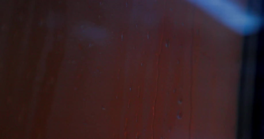 Water droplets run down a window pane