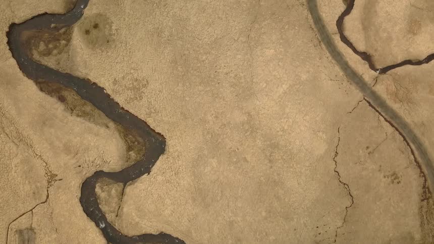 A river winds across a dirt surface