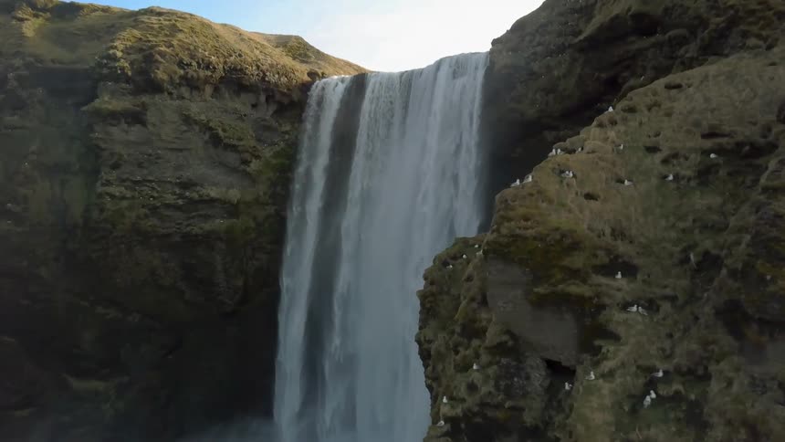A waterfall flows over a rocky cliff