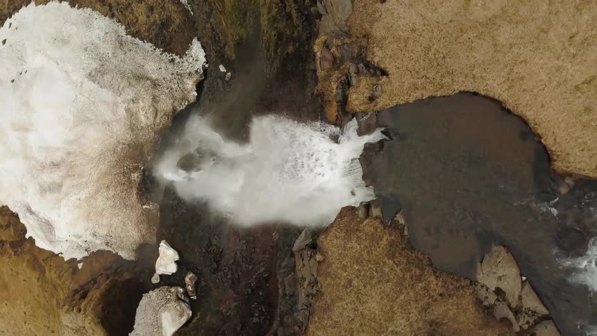 A waterfall flows over a cliff