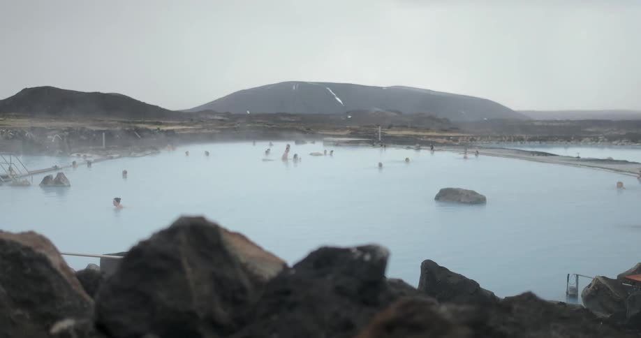 People swim in icelandic hot springs with blue water