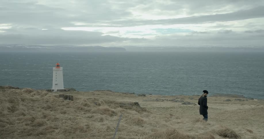 Person walking down towards a lighthouse