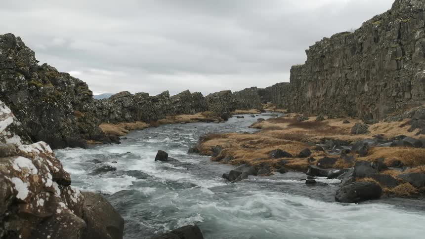 A river flows by rocky cliffs