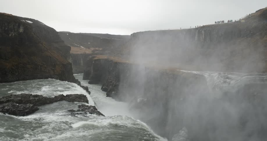 A powerful waterfall flows over a cliff