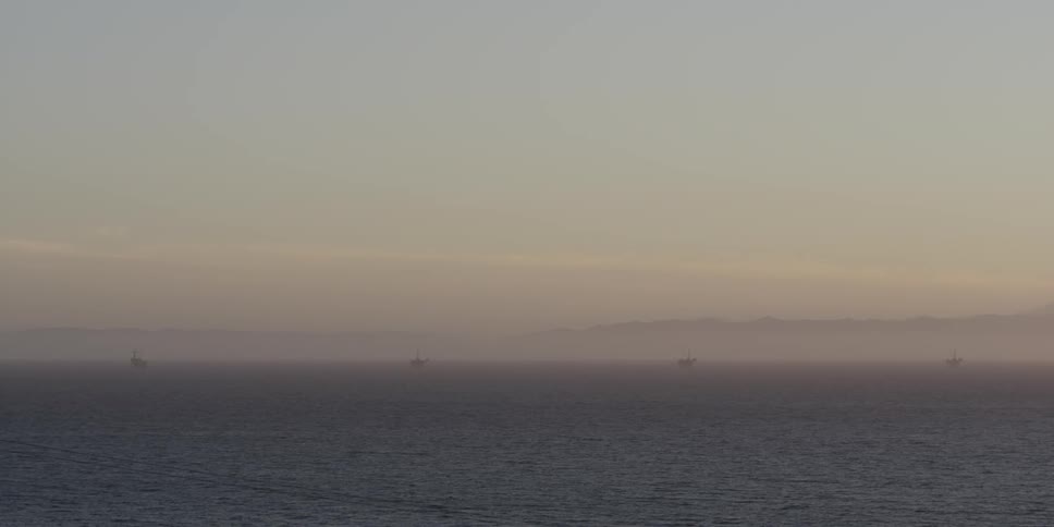 Large body of water with fog and boats in the far distance