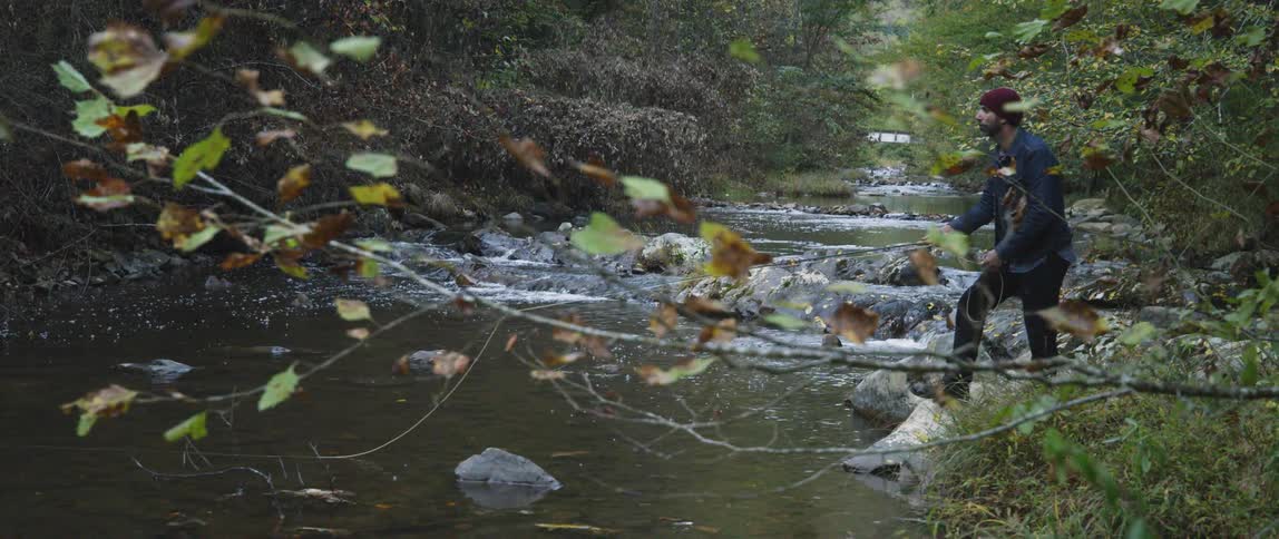 A man fishes in a small stream