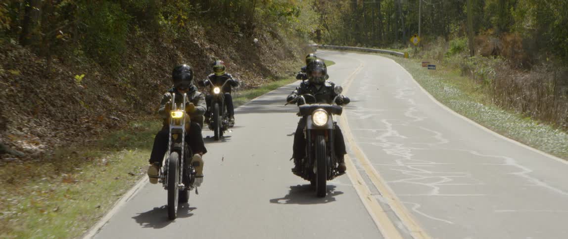 Motorcyclists ride down a mountain road