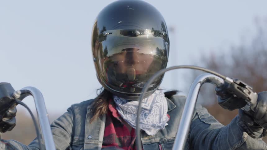 A woman sits on a motorcycle