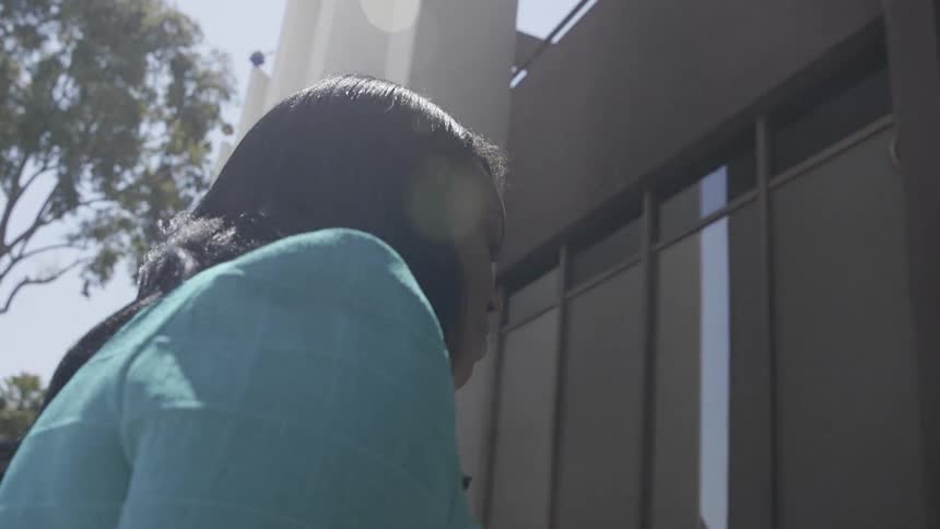 A woman walks towards the front of a building