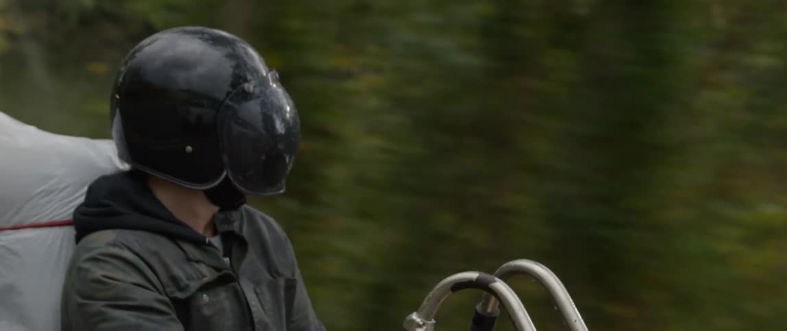 A motorcyclist rides down a road