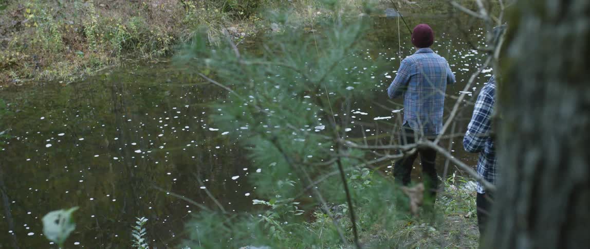 Two men fish in a river