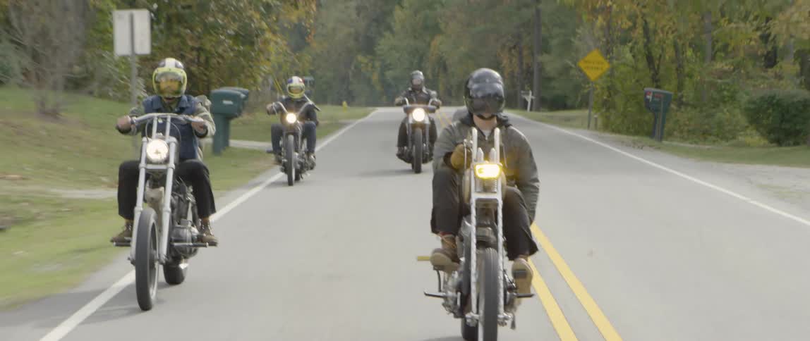 Motorcyclists ride on a neighborhood road