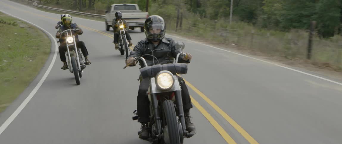 Motorcyclists ride down a mountain road