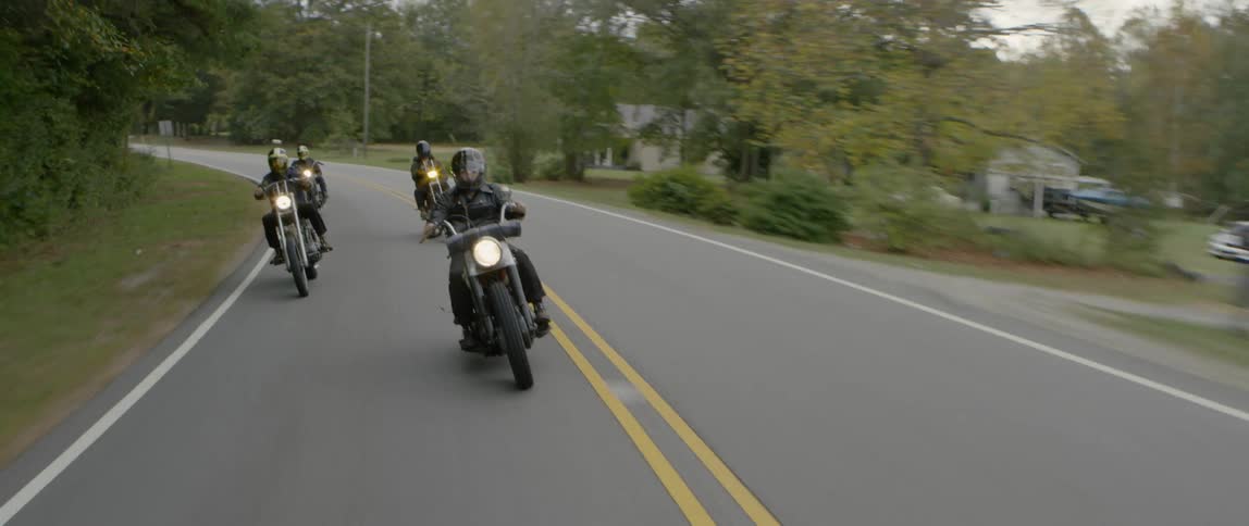 Motorcyclists ride together down the road