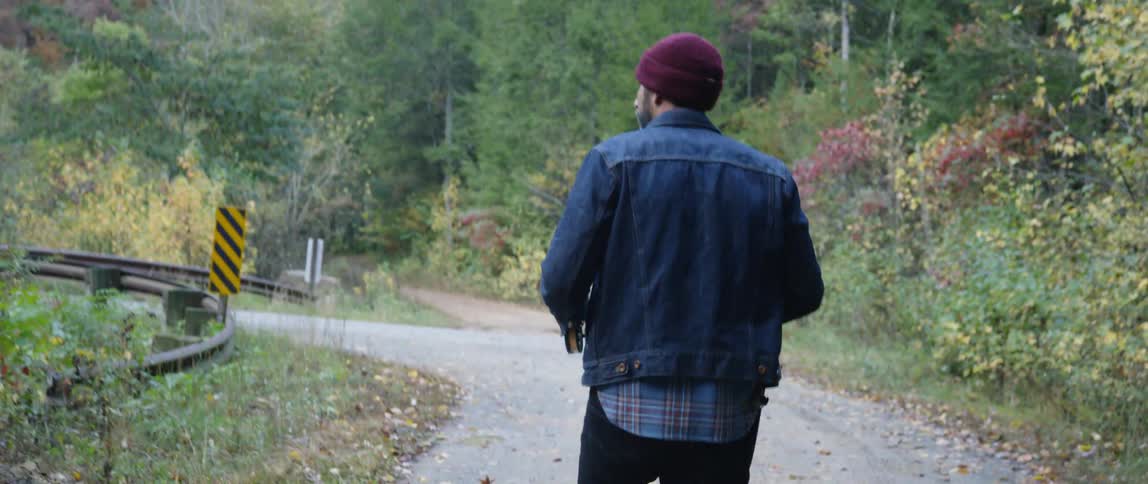 A man walks along a woods trail