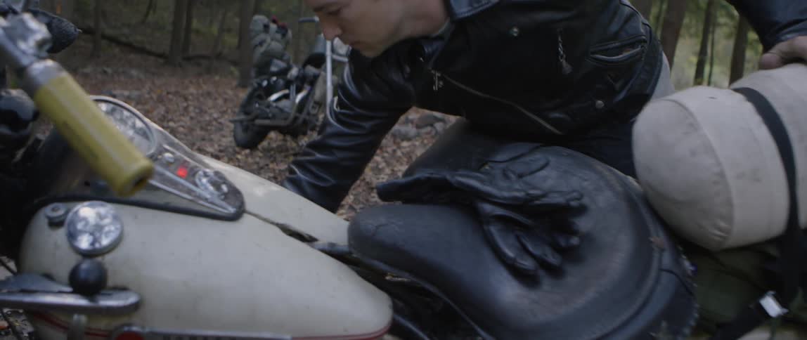 A man attempts to kick start his motorcycle