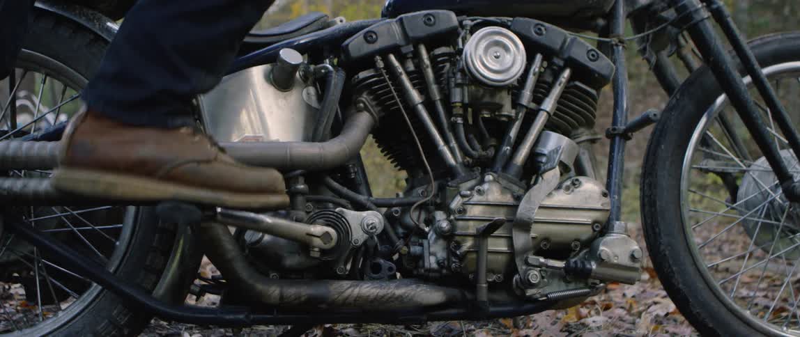 A motorcyclist kick starts the engine