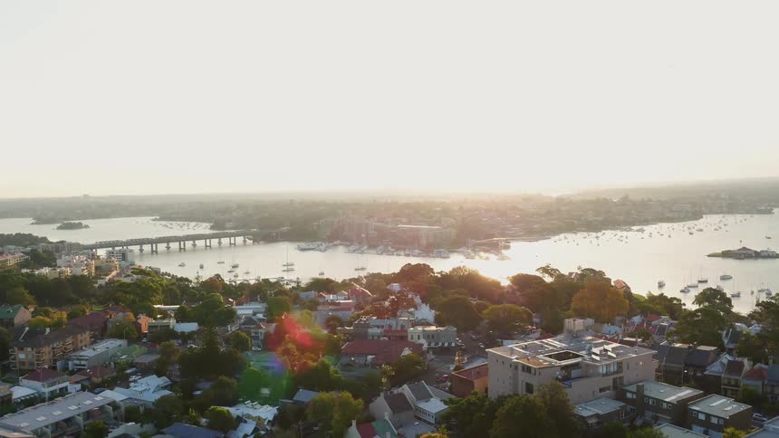 Boats are floating docked in the bay of a coastal town during the day