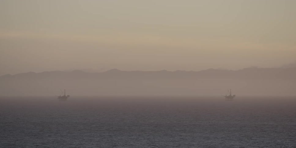 Foggy body of water with a couple of ships on a foggy day