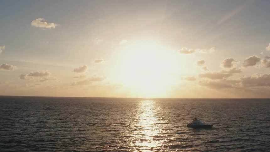 A boat on the ocean at sunset
