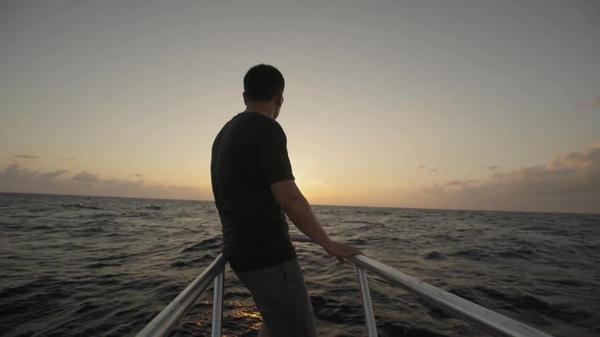 A man leans against the bow of a boat