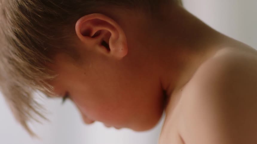 A young boy sits indoors