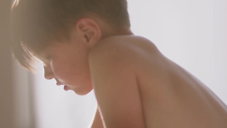 A shirtless boy plays indoors