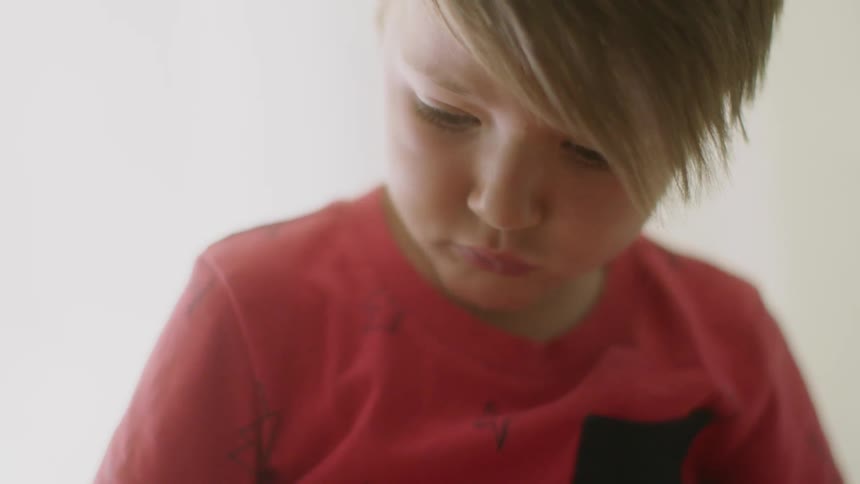 A boy looks down as he plays with something