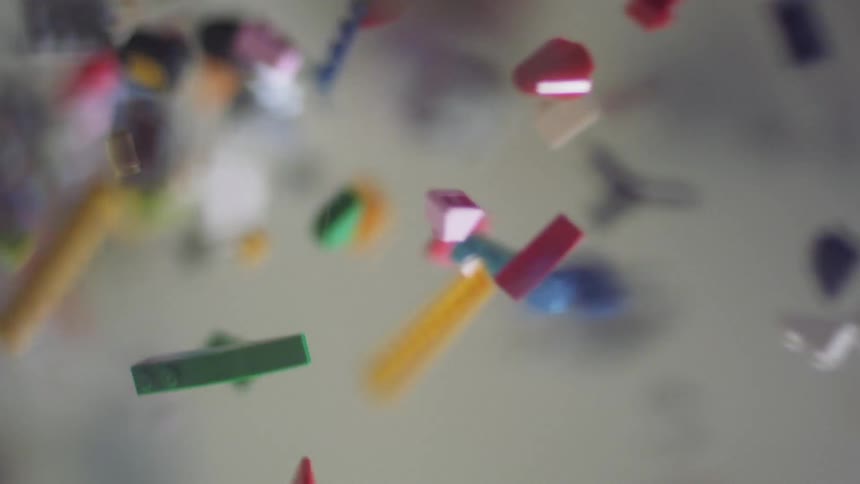 Various colored and shaped legos falling from above