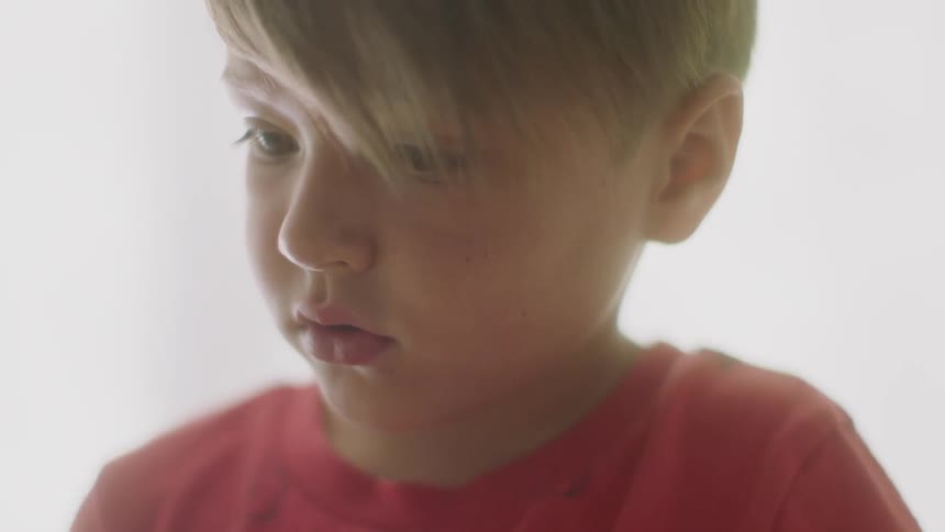 A young boy sits indoors