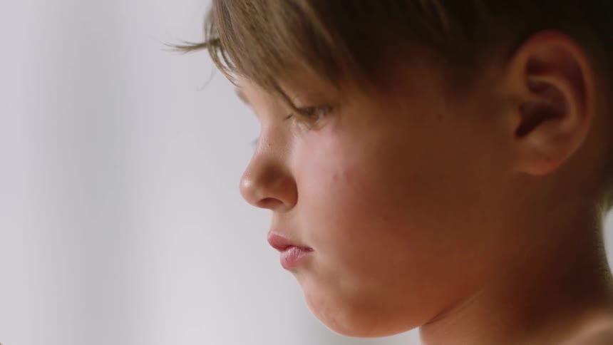 A young boy sits indoors