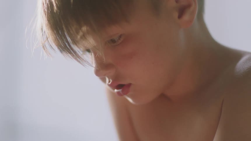 A boy looks down at something in his hand