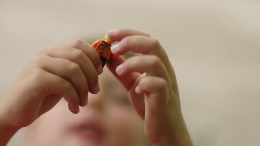 A boy plays with a toy figurine