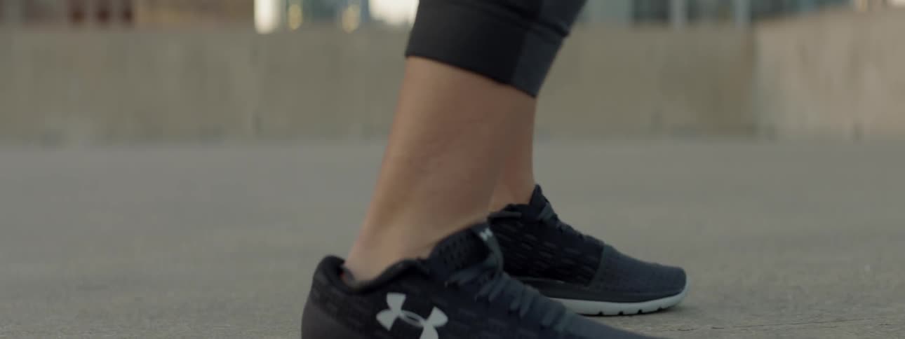 A female athlete is training on a rooftop in a city during the day