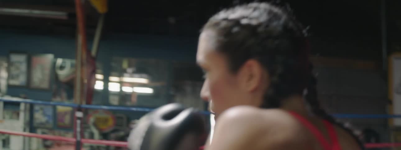 Woman learning to box with a trainer in a boxing ring