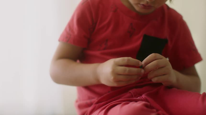 A boy plays with a small toy