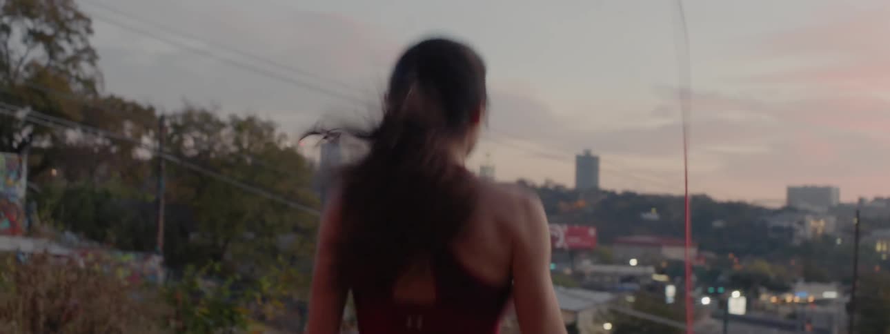 Woman jumping rope at sunset in a large city