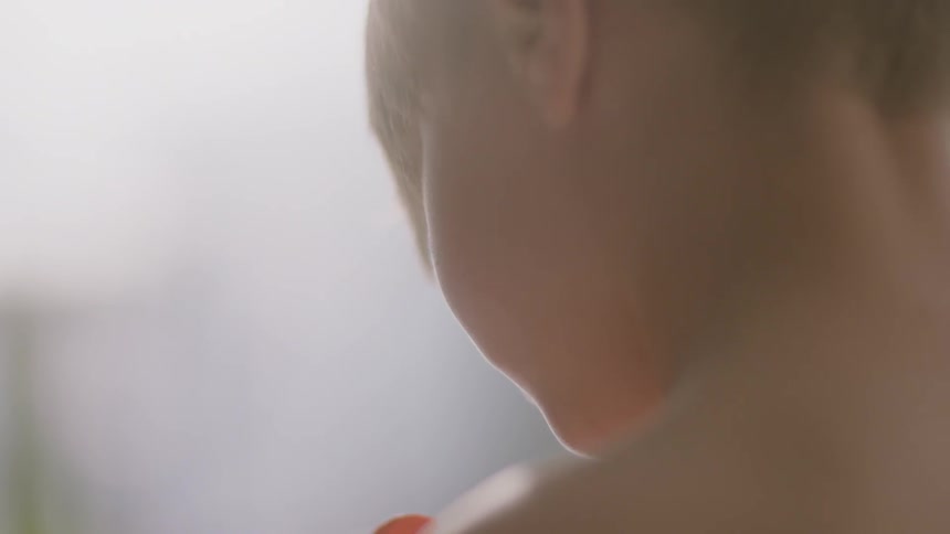 A boy looks down at something in his hand