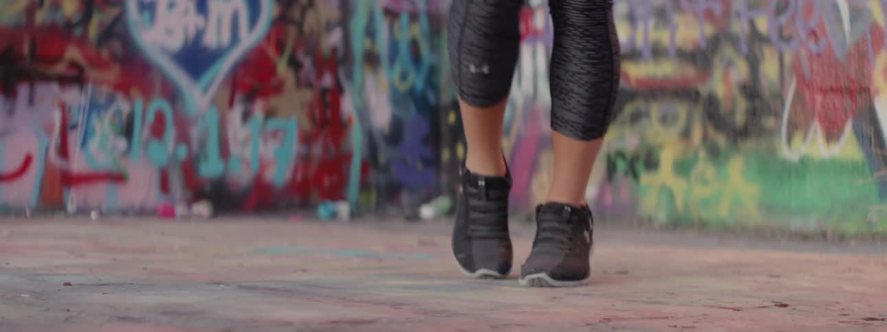 A woman uses a jump rope near graffiti