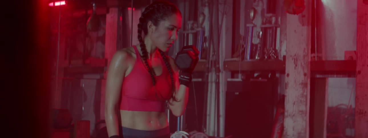 A woman lifts weights in a gym